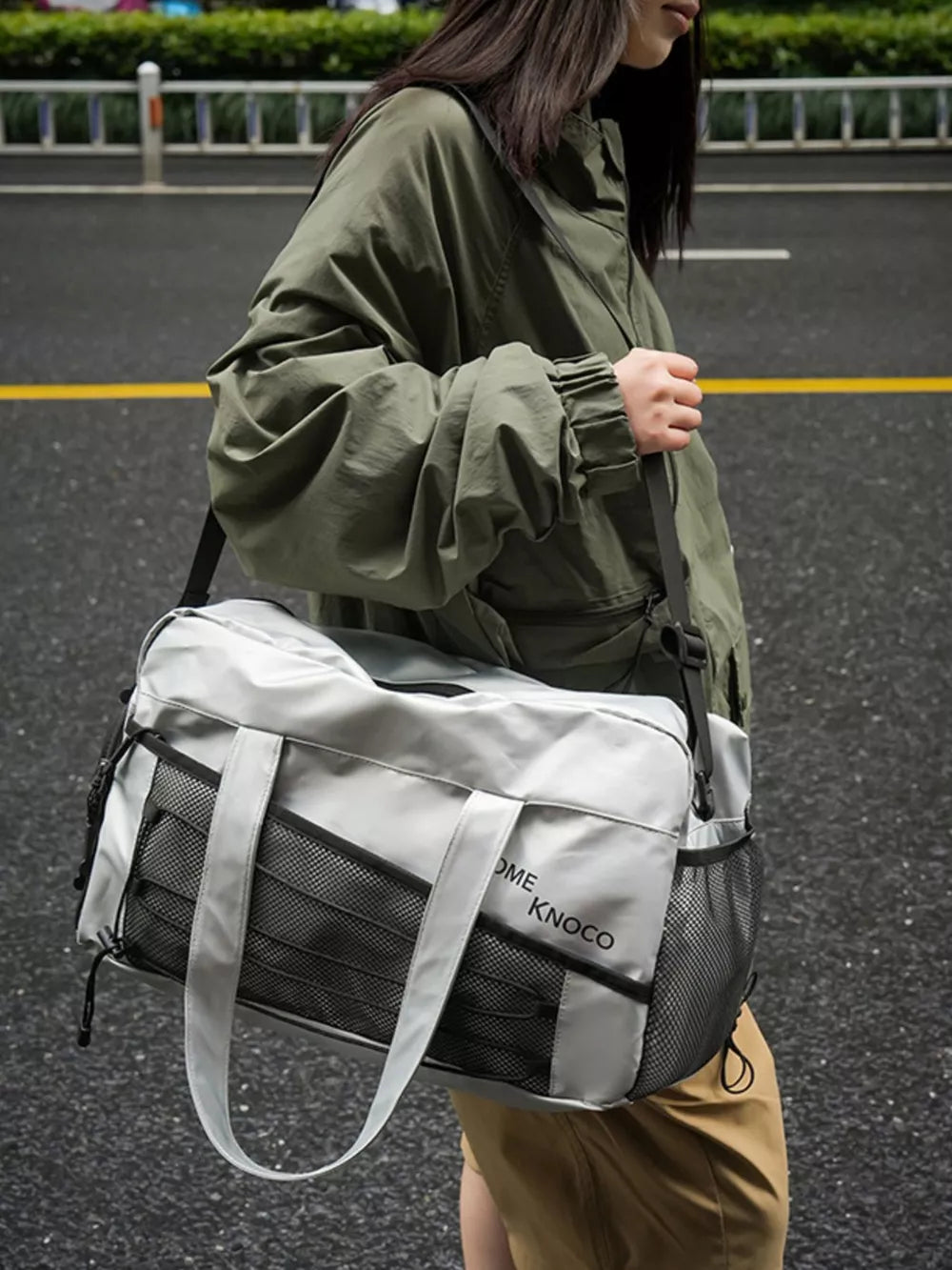 Sleek grey duffel bag with mesh pockets and adjustable strap, perfect for gym or travel.