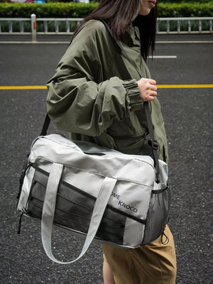 Sleek grey duffel bag with mesh pockets and adjustable strap, perfect for gym or travel.