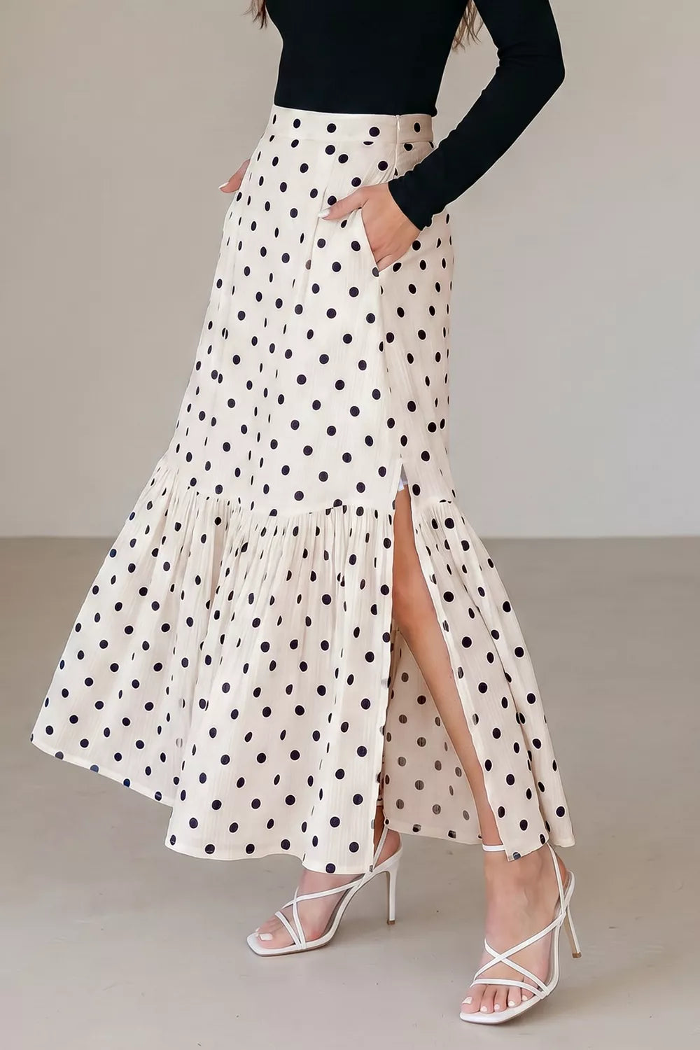 Chic polka dot maxi skirt in beige with ruffles and side slits.
