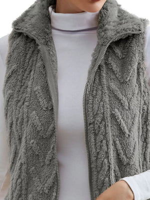 Dark gray faux fur zip-up vest with chevron pattern and stand-up collar.