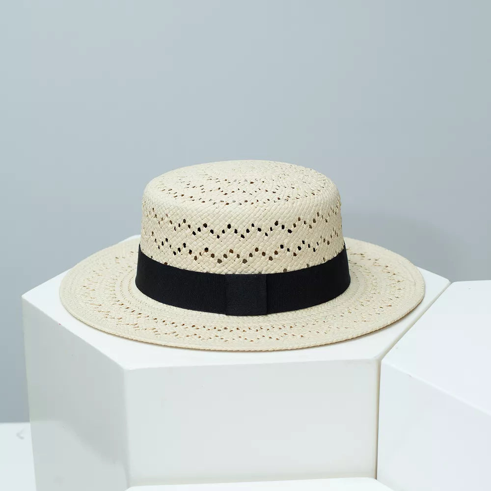 Classic woven straw boater hat in off-white with black ribbon band and eyelet detail