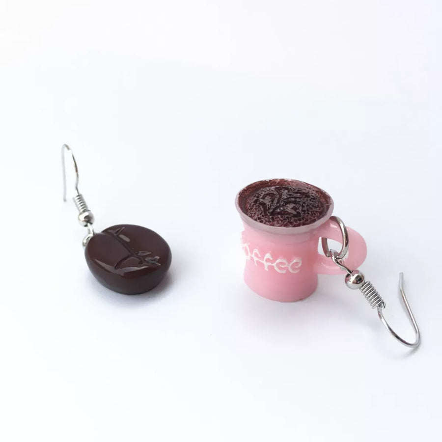 Blush pink coffee cup and coffee bean drop earrings with white lettering.