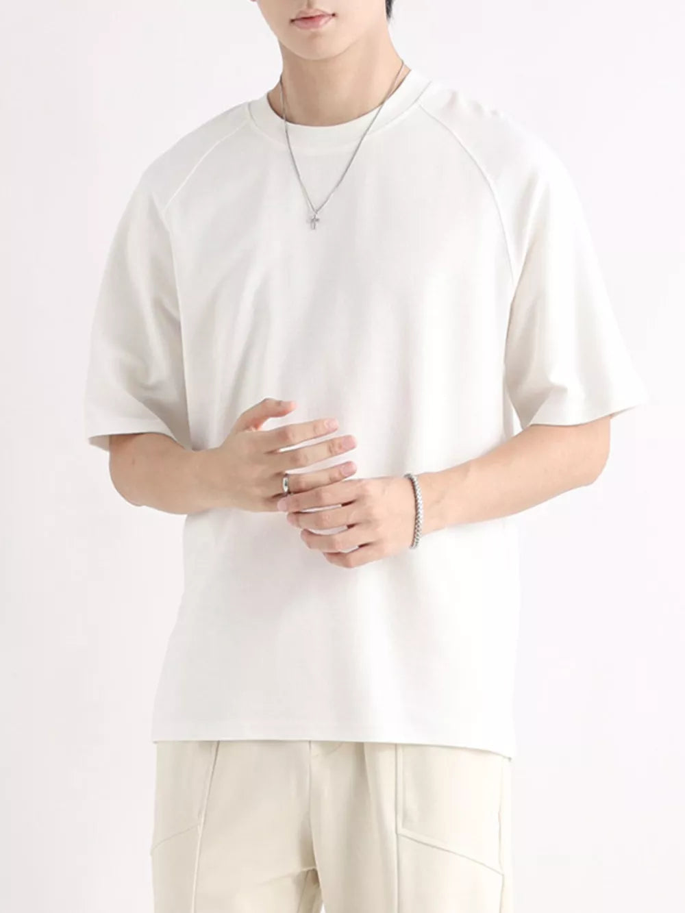 Men's white cotton t-shirt with relaxed fit and raglan sleeves.