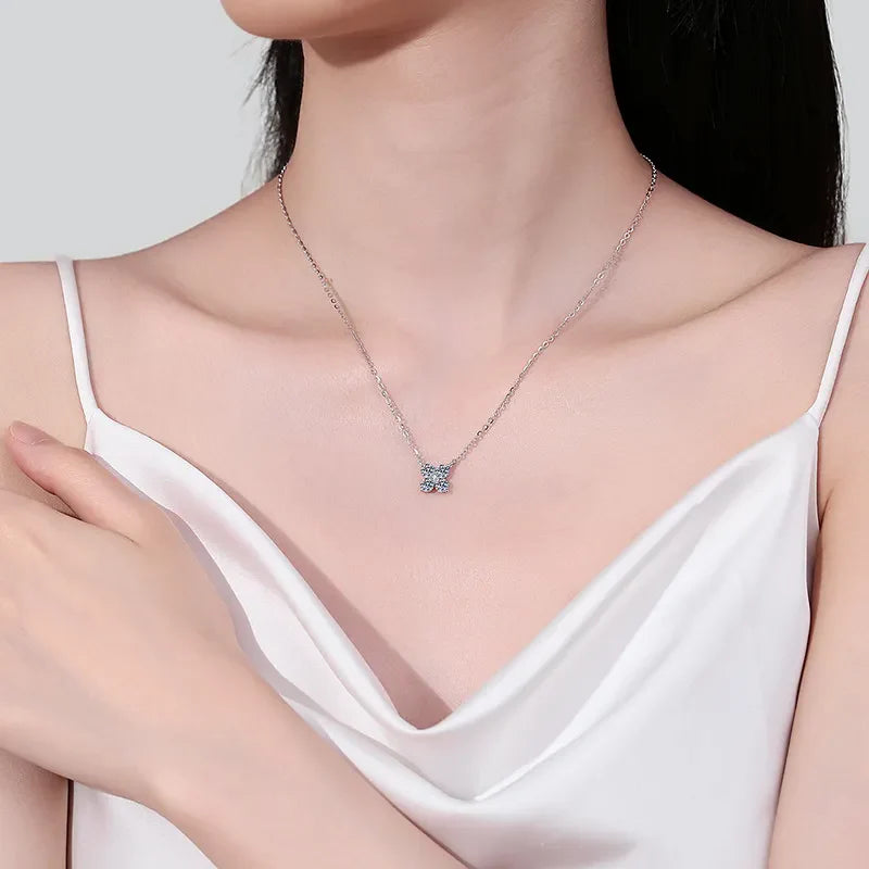 Silver four-stone moissanite clover necklace with delicate chain.