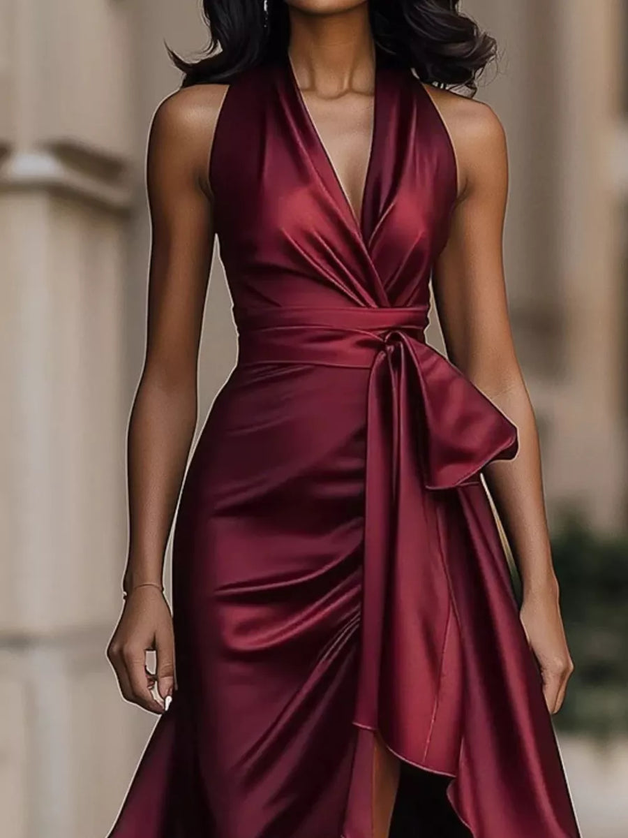 Burgundy halter maxi dress with ruffled asymmetrical hem and belted waist.