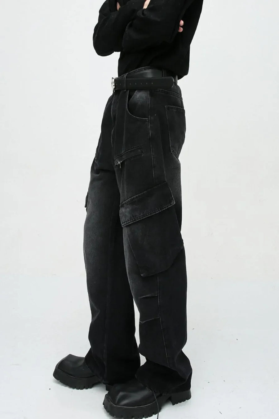 Baggy black denim cargo pants with zipper pockets and large flap pockets.