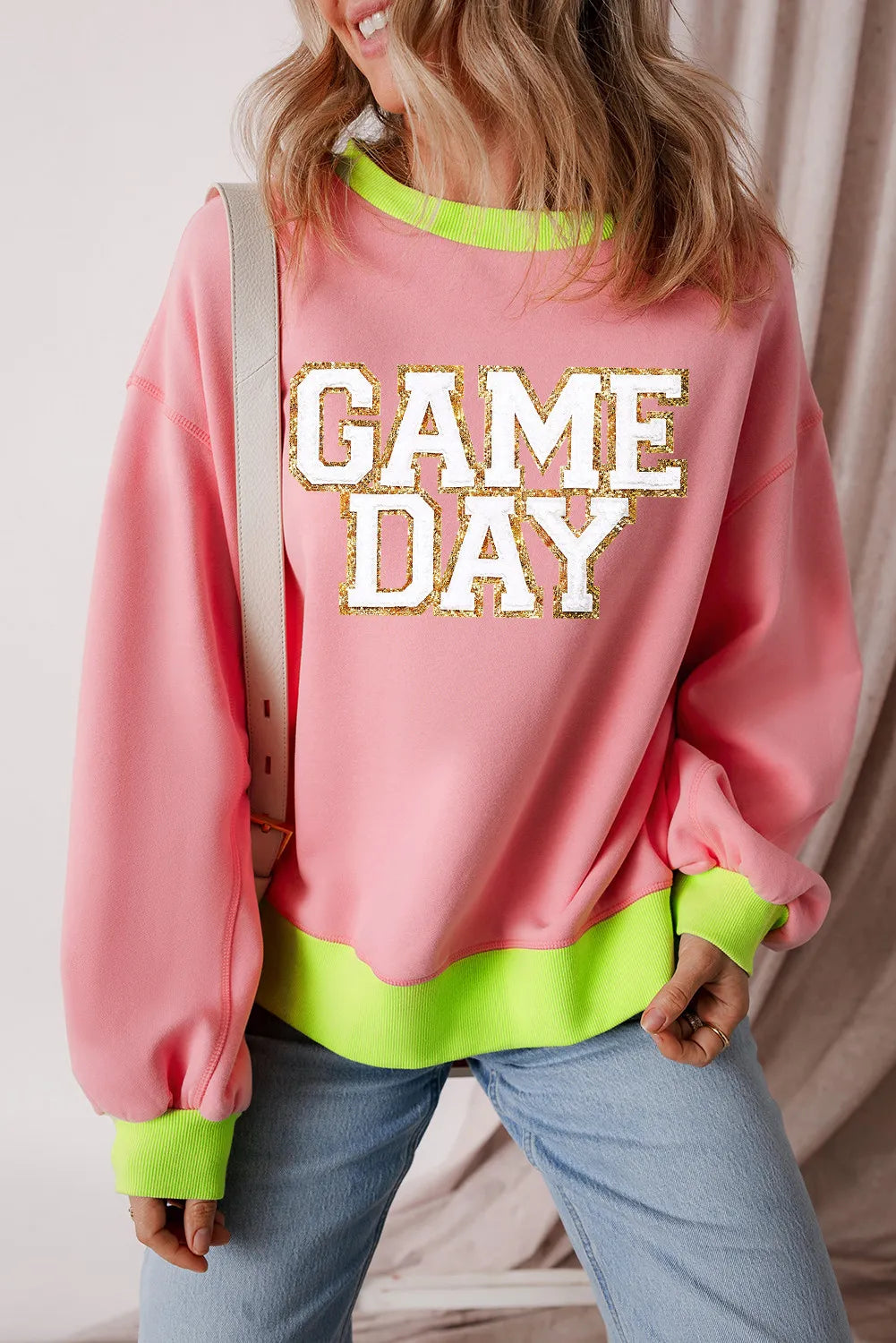 Blush pink sweatshirt with neon trim and glitter appliqué "GAME DAY" graphic.