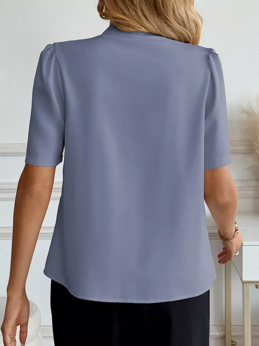 Blue V-neck short sleeve shirt with puff sleeves and a button-down front, shown from the back.