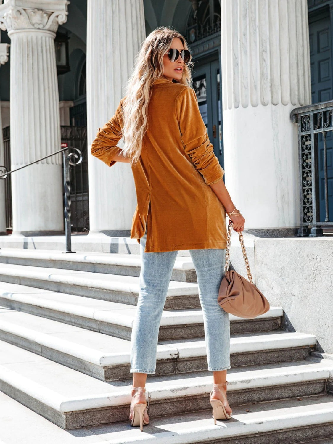 Velvet blazer in caramel with drape-front and button detail, styled with jeans.