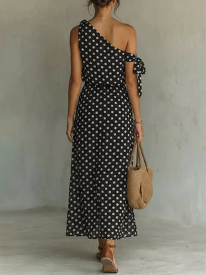 Black polka dot one-shoulder maxi dress with tie detail on sleeve.