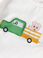 White cotton baby tee with embroidered green truck and pig detail