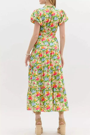 Vibrant floral maxi dress with ruffled neckline, smocked waist, tiered skirt, and puff sleeves.