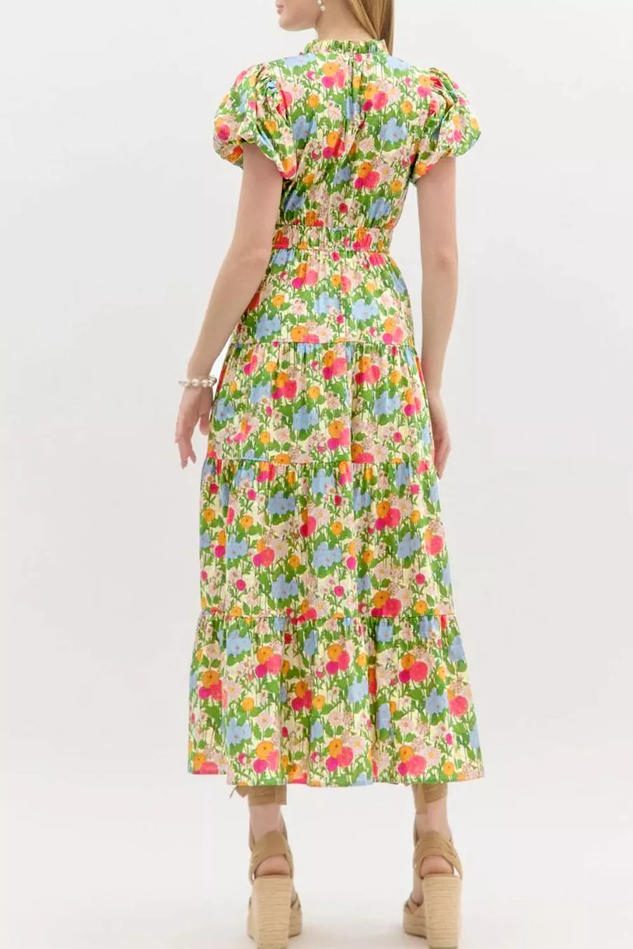 Vibrant floral maxi dress with ruffled neckline, smocked waist, tiered skirt, and puff sleeves.