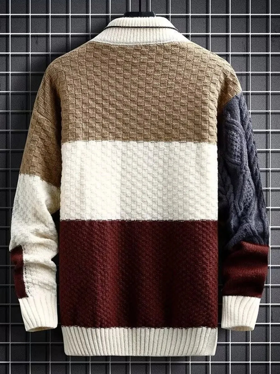 Men's color block cable-knit pullover sweater with textured panels and ribbed collar.