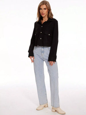 Black trucker jacket with snap buttons and chest pockets, long sleeves, cropped length.