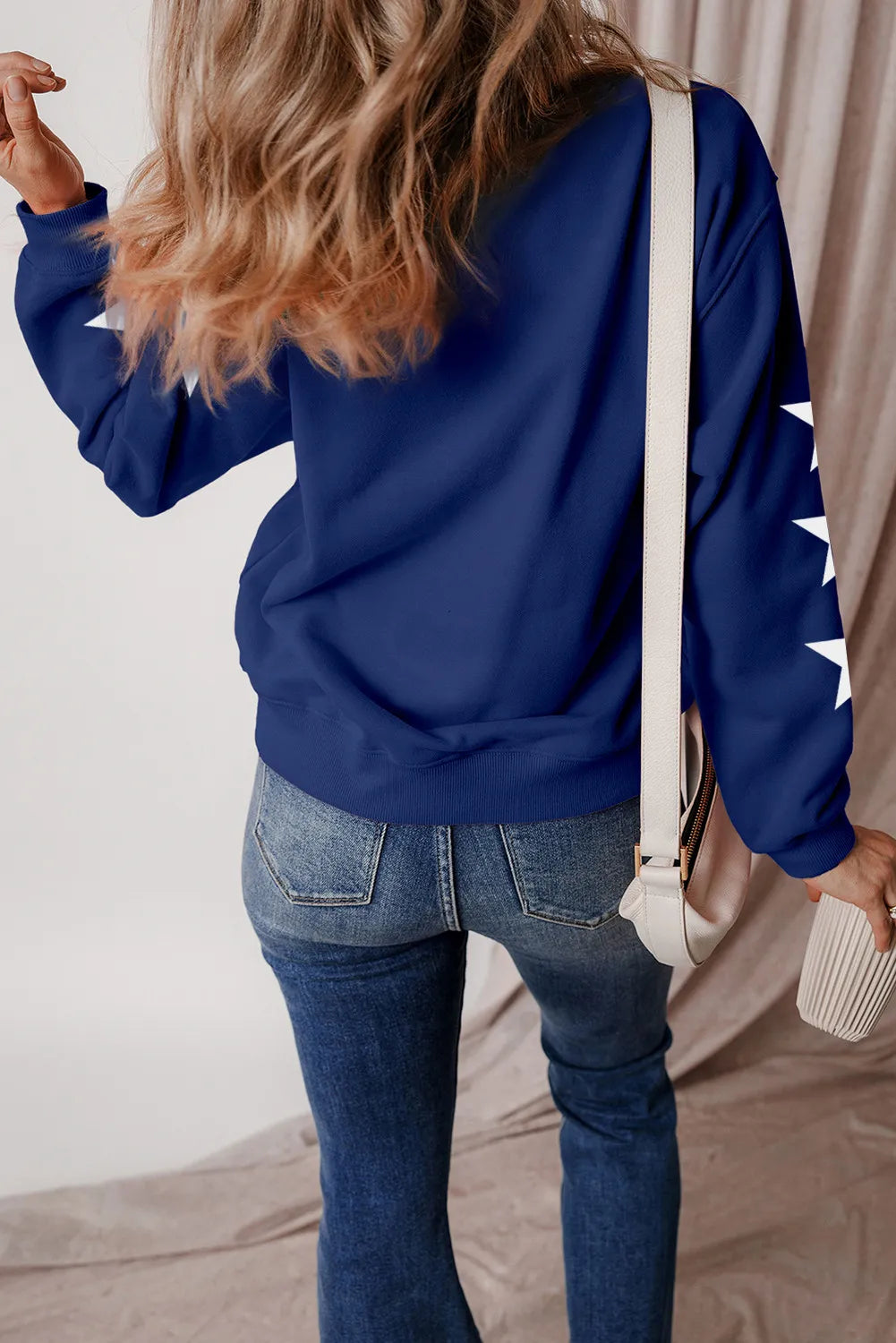 Navy graphic sweatshirt with white stars on sleeves, crewneck, cotton-polyester blend.