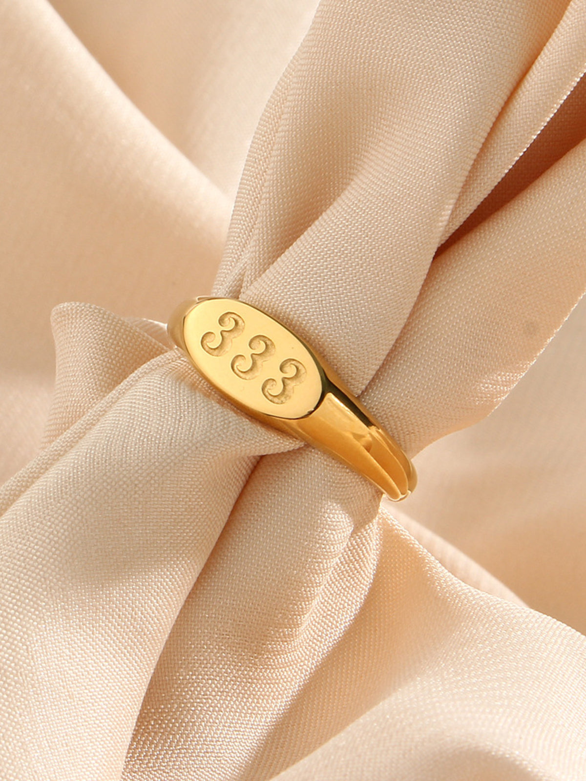 gold ring featuring engraved detail and numeric motif