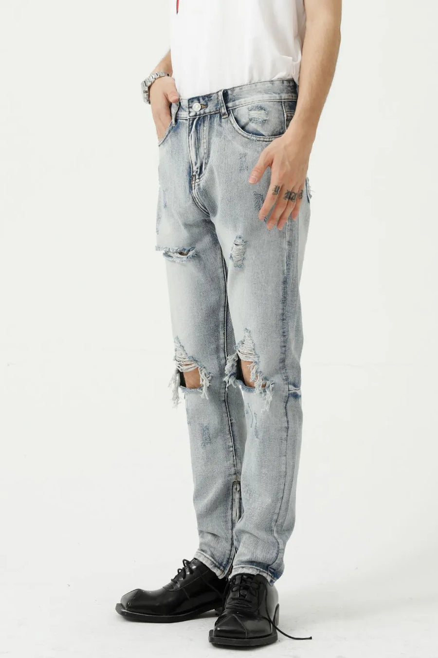 Light wash denim jeans with ripped knees and a slim fit, styled casually.