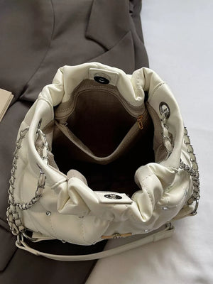 White quilted shoulder bag with diamond pattern, chain strap, and rhinestone star details.