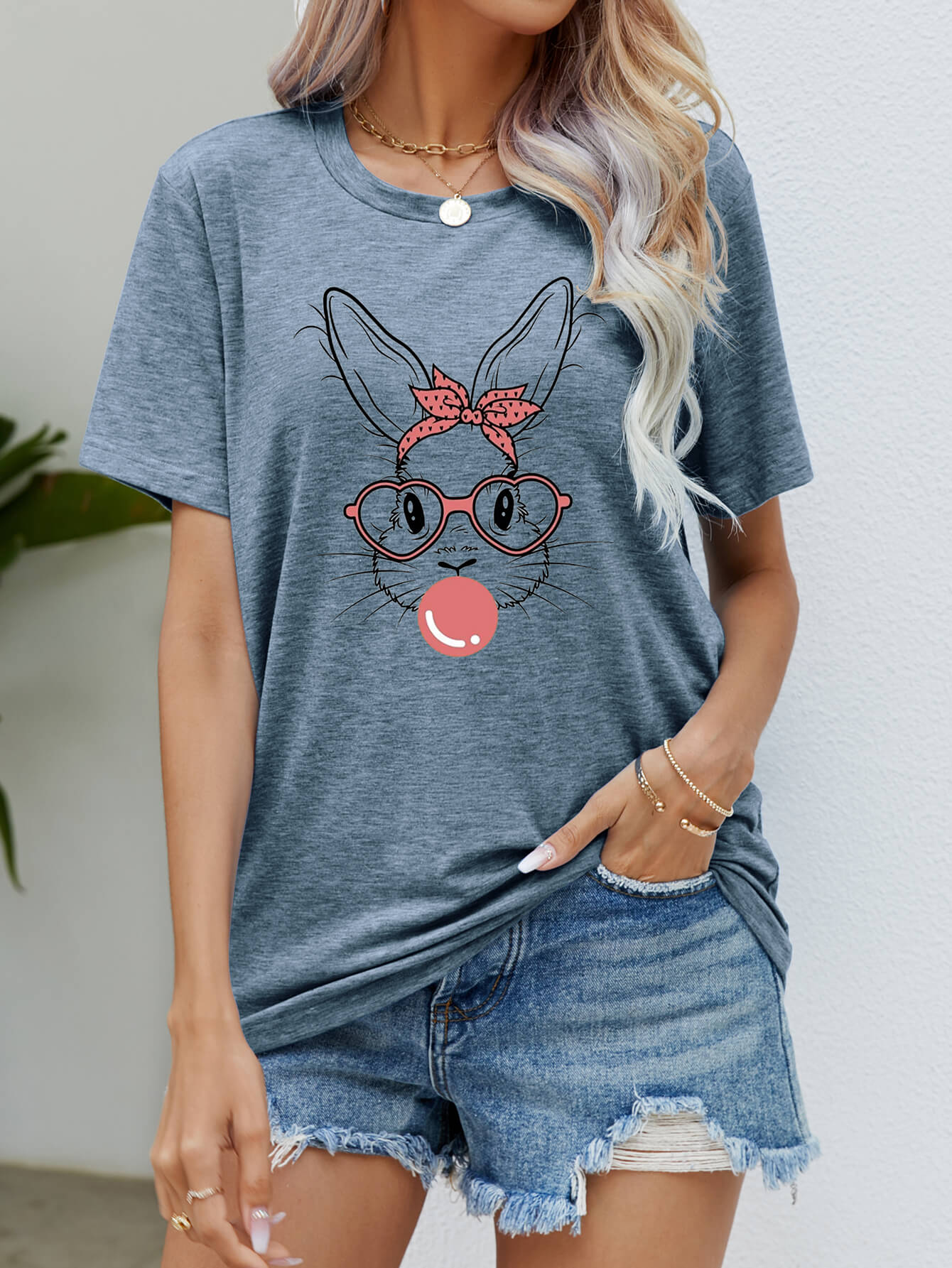 Misty Blue graphic tee with a bunny wearing a bandana and glasses blowing bubblegum.