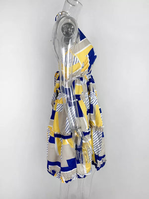 Abstract print halter mini dress with yellow, blue, and gray geometric pattern and tiered ruffles.