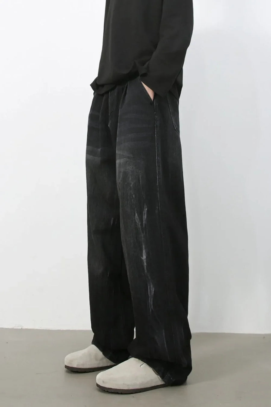 Dark wash pleated wide-leg denim trousers with distressed details
