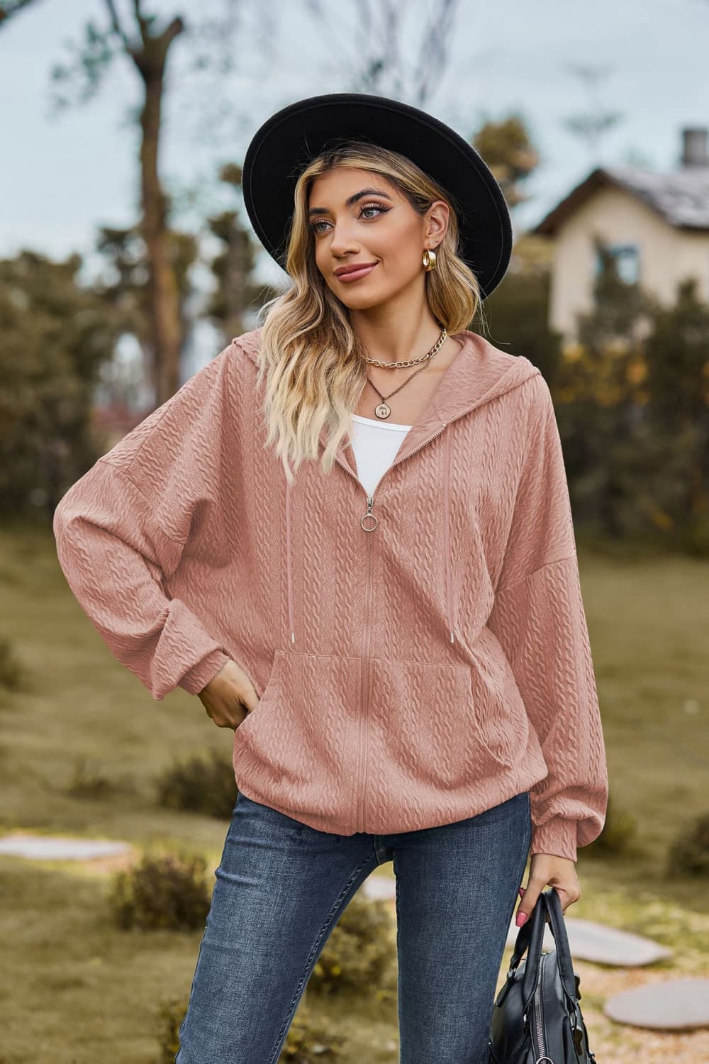 Textured cable knit zip-up hoodie in dusty pink with a relaxed fit and front pockets.