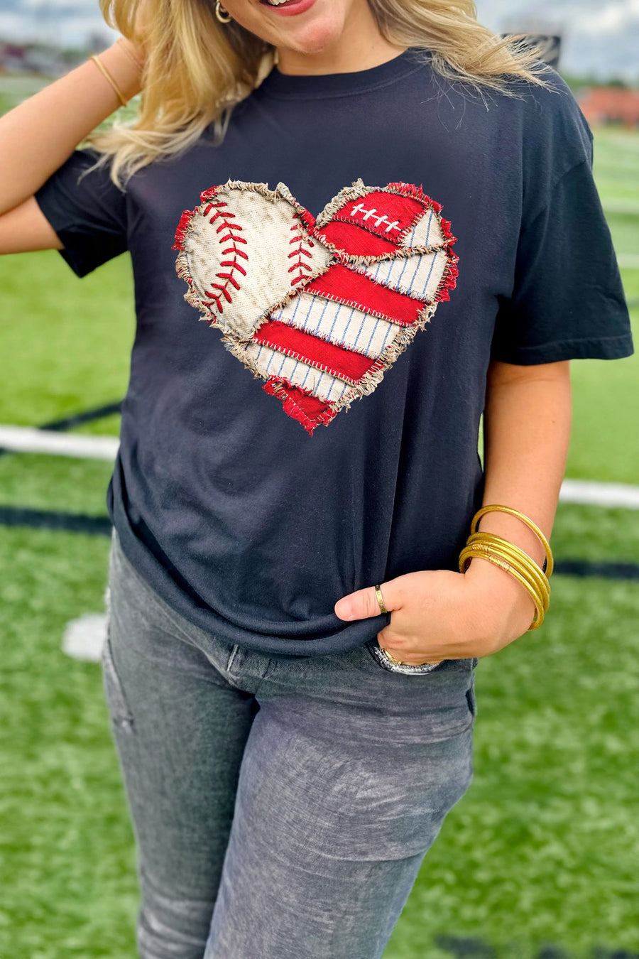 Distressed heart graphic t-shirt in navy with baseball and red stripe patches.