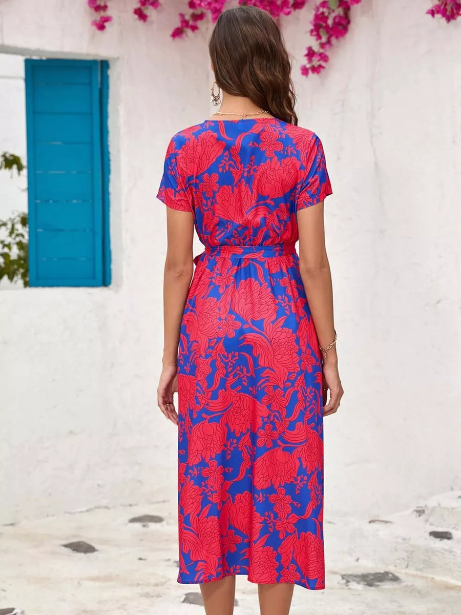 Midi wrap dress in blue with a red floral print, short sleeves, and a tie waist.