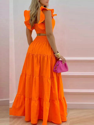 Orange ruffled crop top and tiered maxi skirt set with smocked waist.