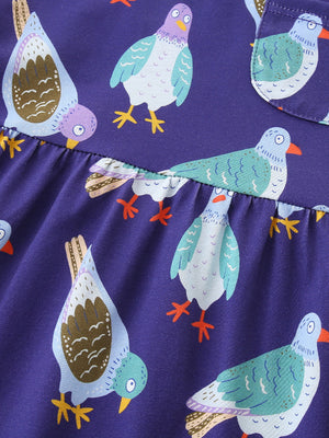 Toddler dress in purple with a playful pigeon print, featuring a ruffled hem detail.
