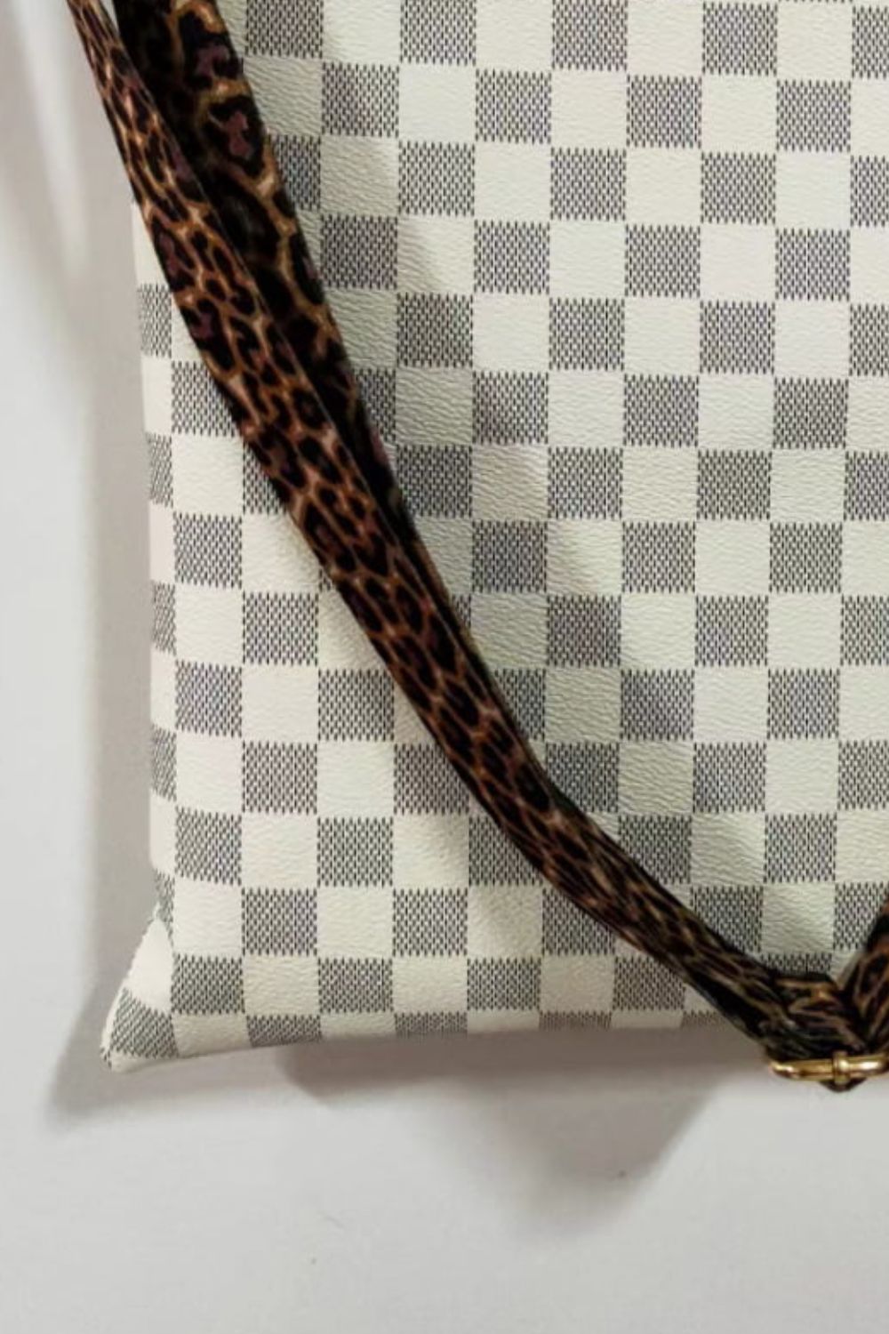 Cream crossbody bag with leopard print strap and checkered pattern