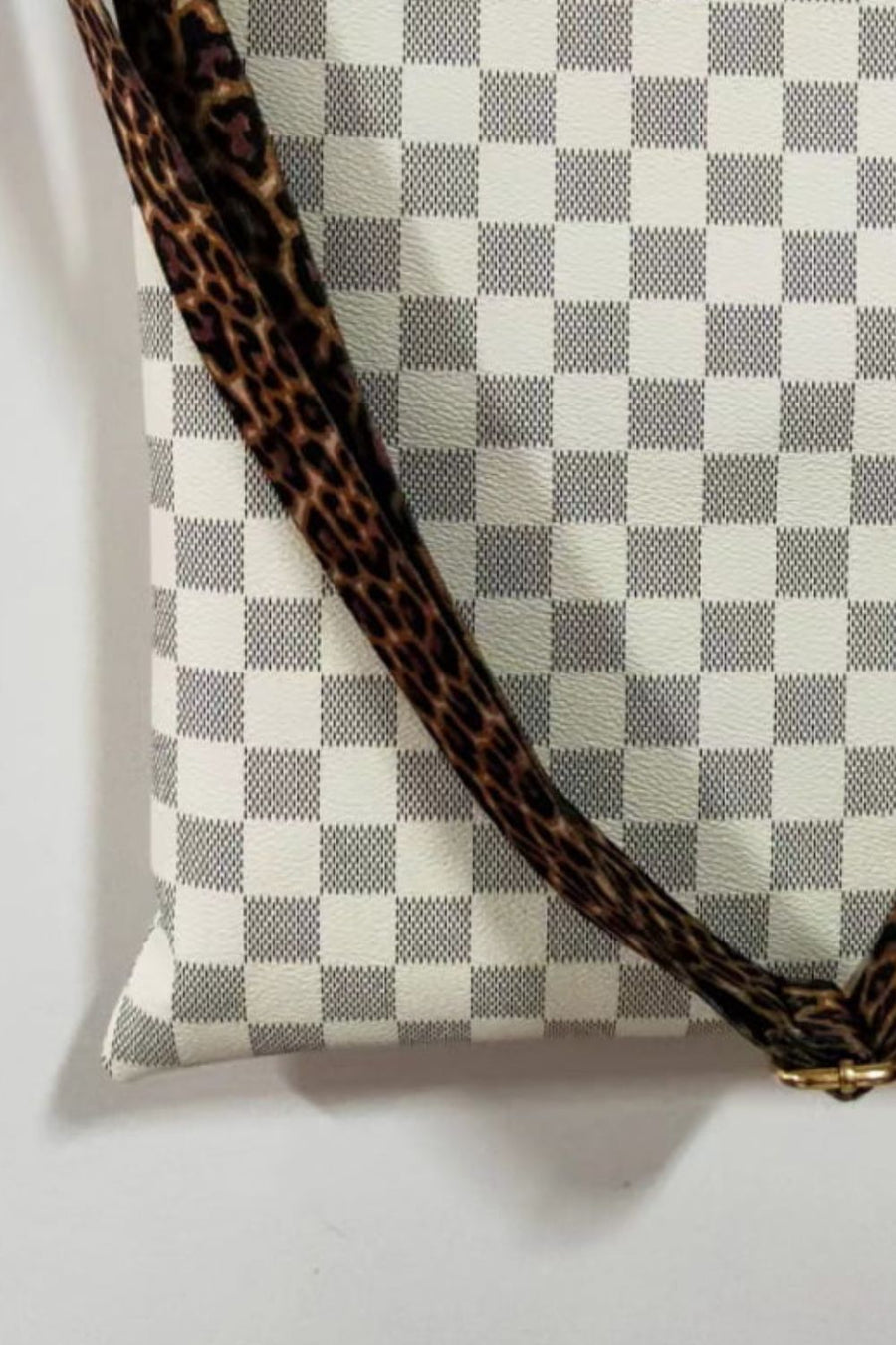Cream crossbody bag with leopard print strap and checkered pattern