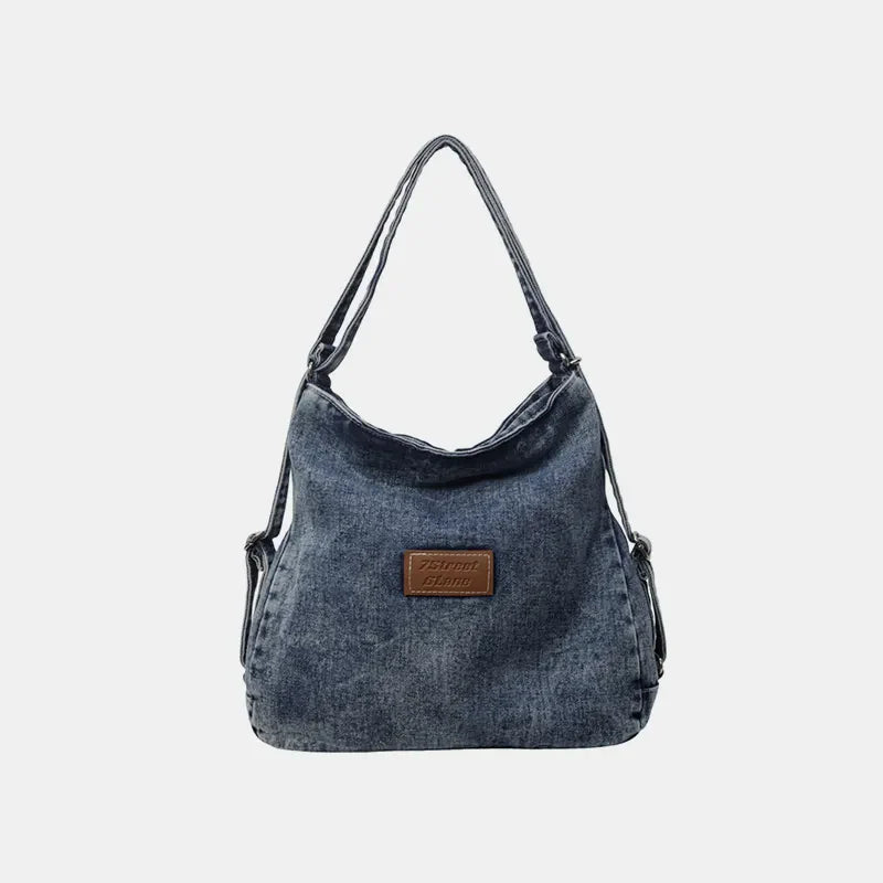 Denim hobo bag with leatherette patch in medium wash.