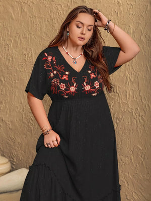 Black plus size maxi dress with V-neck and embroidered floral detail, short sleeves, tiered hem.