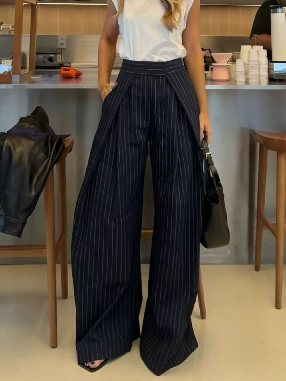 Wide-leg pants in dark blue with white pinstripes, featuring a high waist and flowing silhouette.