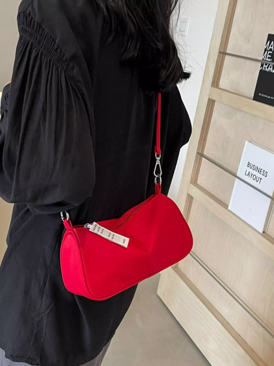 Red nylon mini crossbody bag with a compact design and zipper closure.