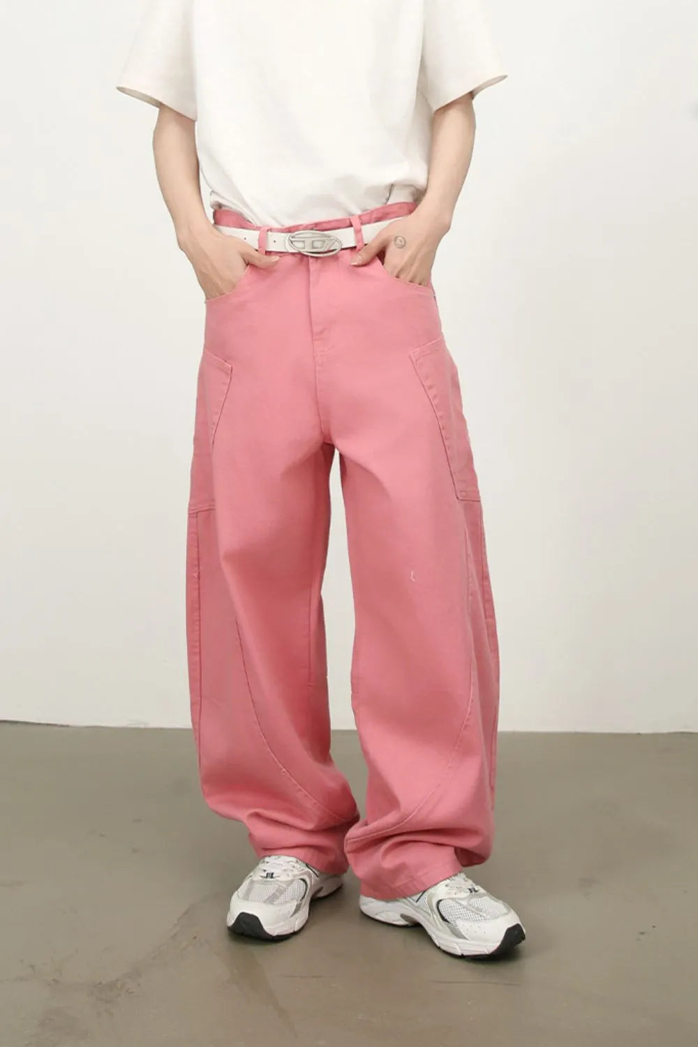 Dusty pink wide leg trousers with sculpted pocket details and a white belt.