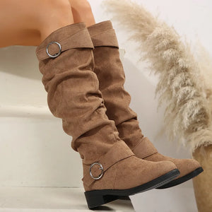 Slouchy taupe knee-high boots with buckle detail and a round silver ring accent.