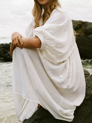 White tie-neck midi dress with puff sleeves and a flowing skirt.
