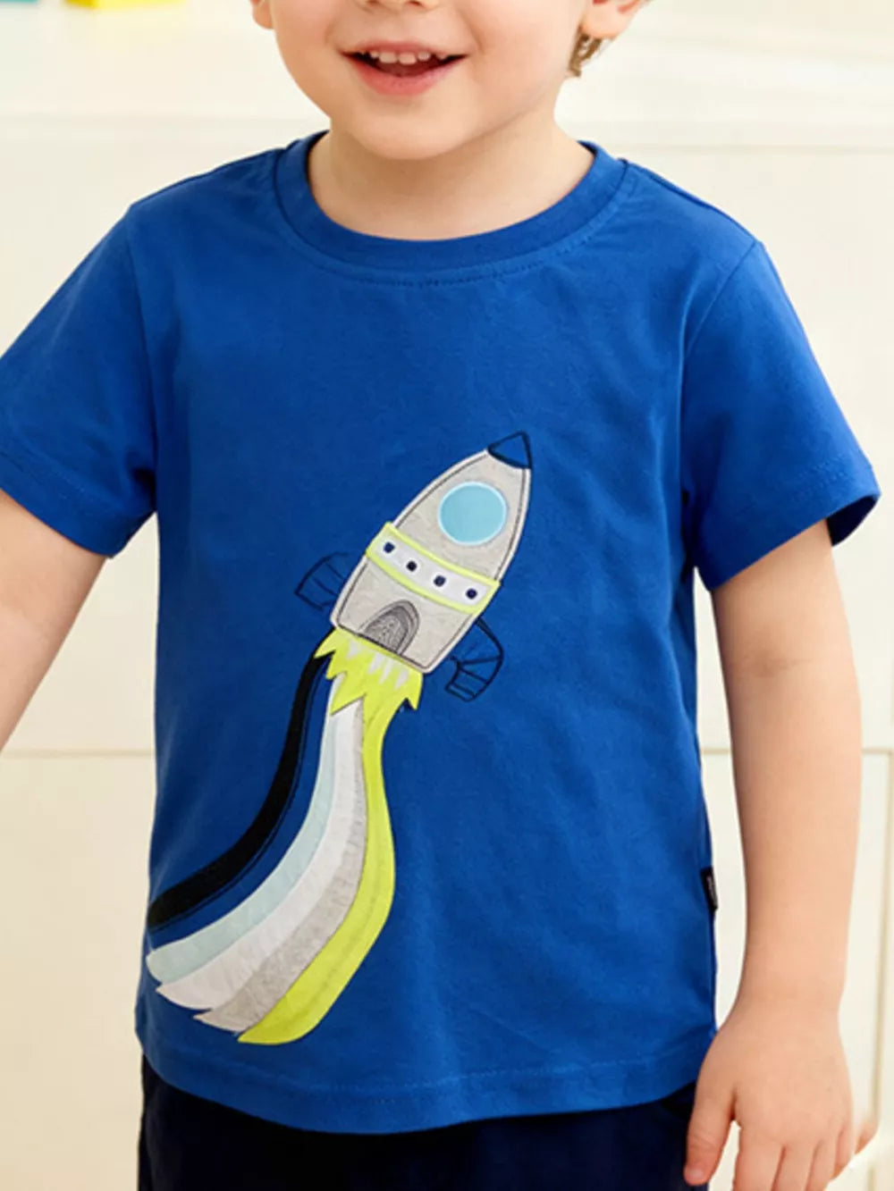 Blue toddler t-shirt with a rocket graphic and colorful flame trail.