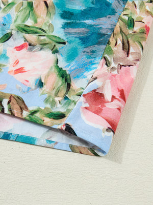 Women's cotton V-neck blouse with a vibrant floral print in pink, blue, and green.