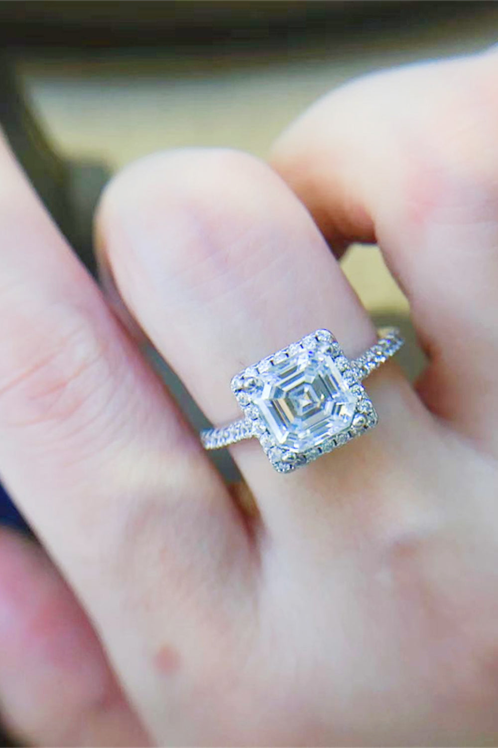Silver Asscher cut moissanite halo ring with a pavé band.