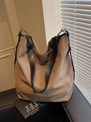 Brown hobo bag with adjustable strap and black leather details