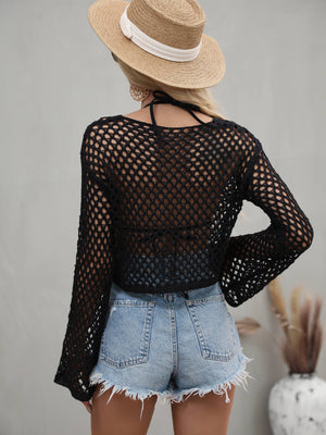 Black open-knit acrylic crop top with bell sleeves, worn over a bikini top.