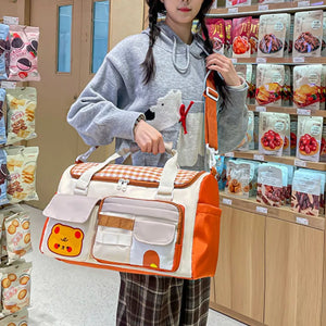 Charming gingham pattern travel bag with double zipper and cute bear applique.