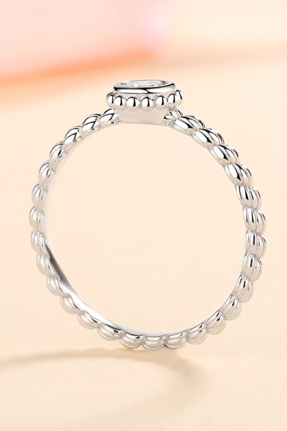 Silver beaded band ring with a solitaire moissanite stone.