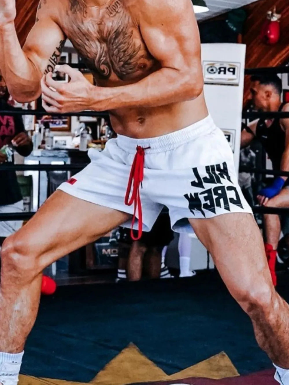 White athletic shorts with red drawstring and black Kill Crew graphic print