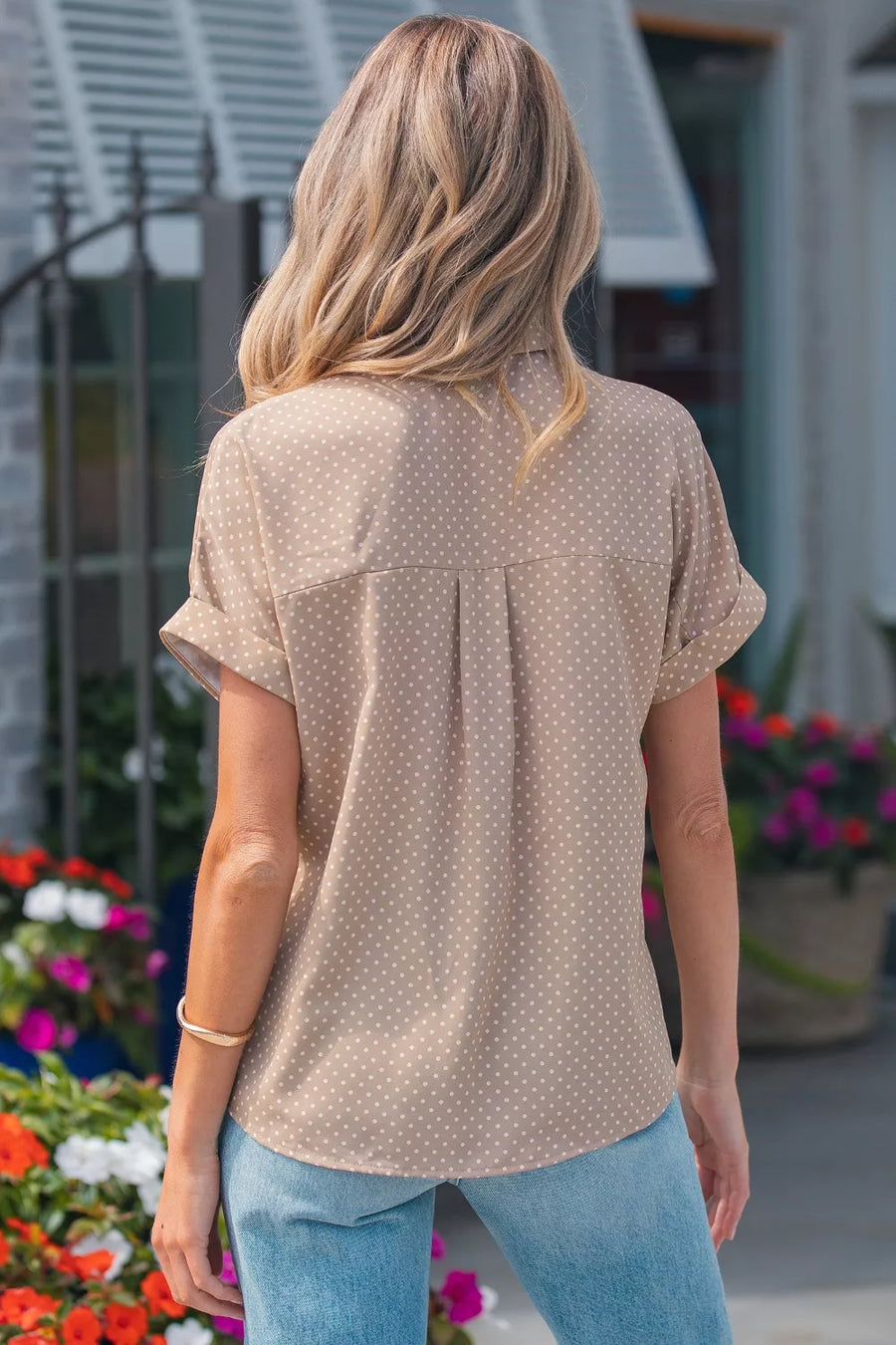 Chic polka dot button-up blouse with cuffed short sleeves and a relaxed fit.