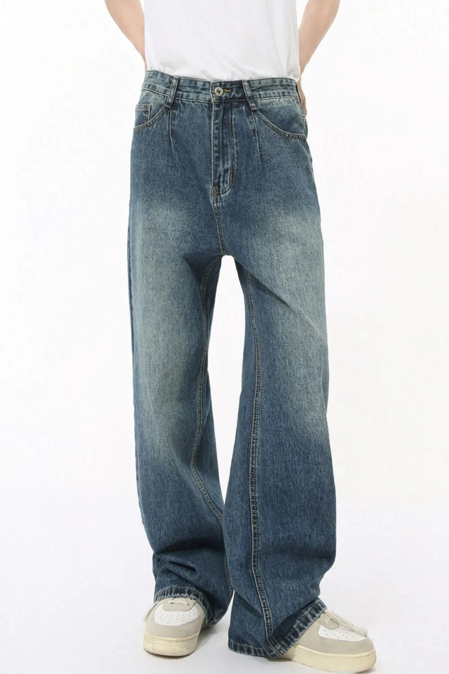 Pleated baggy denim jeans in medium wash with a relaxed fit and wide leg.